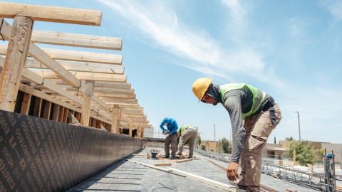 פועל מתכופף להרים חוט ברזל.jpg